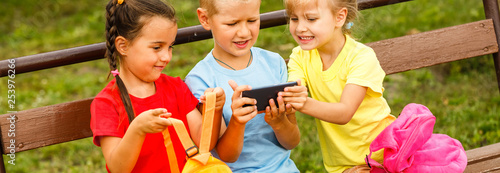 Happy children taking a selfie with smart phone. Themes friendship, summertine and modern technology photo