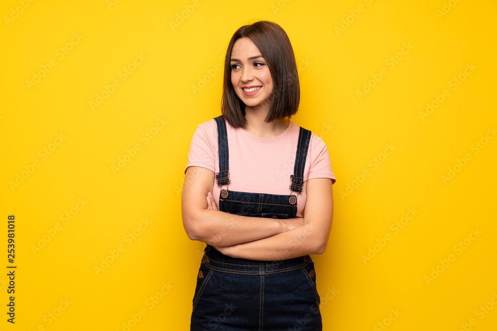 Young woman over yellow wall looking to the side Young woman over yellow wall looking to the side