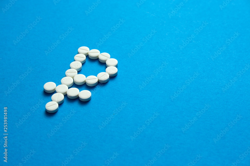 white pills in the shape of a ruble are scattered on a blue background  Copyspace