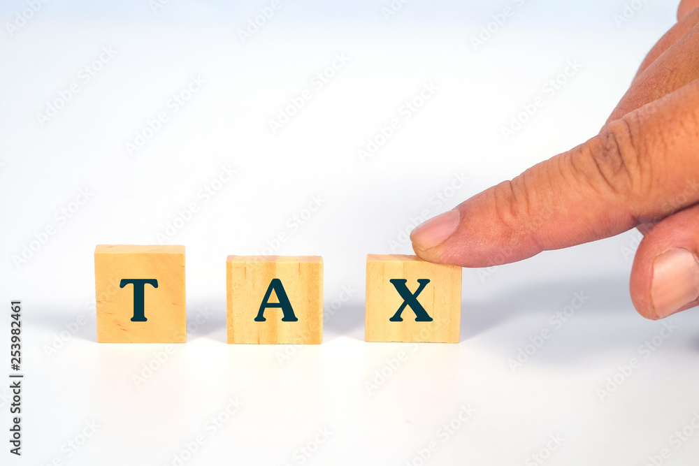 Hand hold a TAX word on wooden cube block.business concept. Hand hold a TAX word on wooden cube block.business concept.