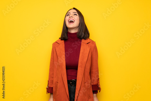 Young woman with coat shouting to the front with mouth wide open © luismolinero