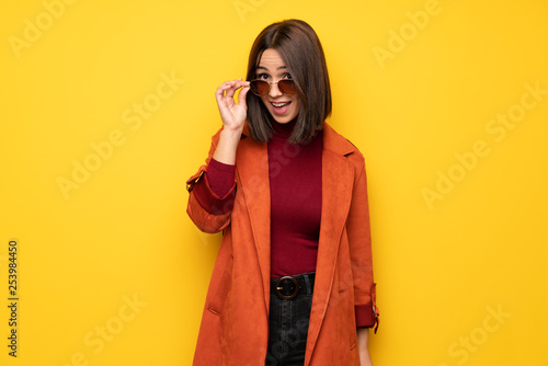 Young woman with coat with glasses and surprised