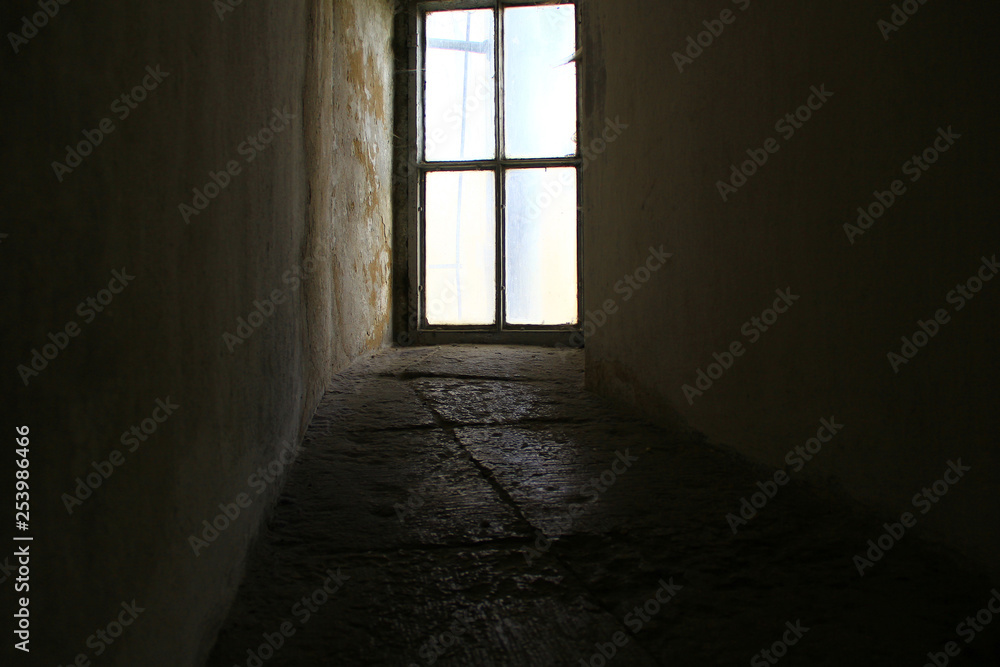 An ancient window at the end of a stone corridor An ancient window at the end of a stone corridor
