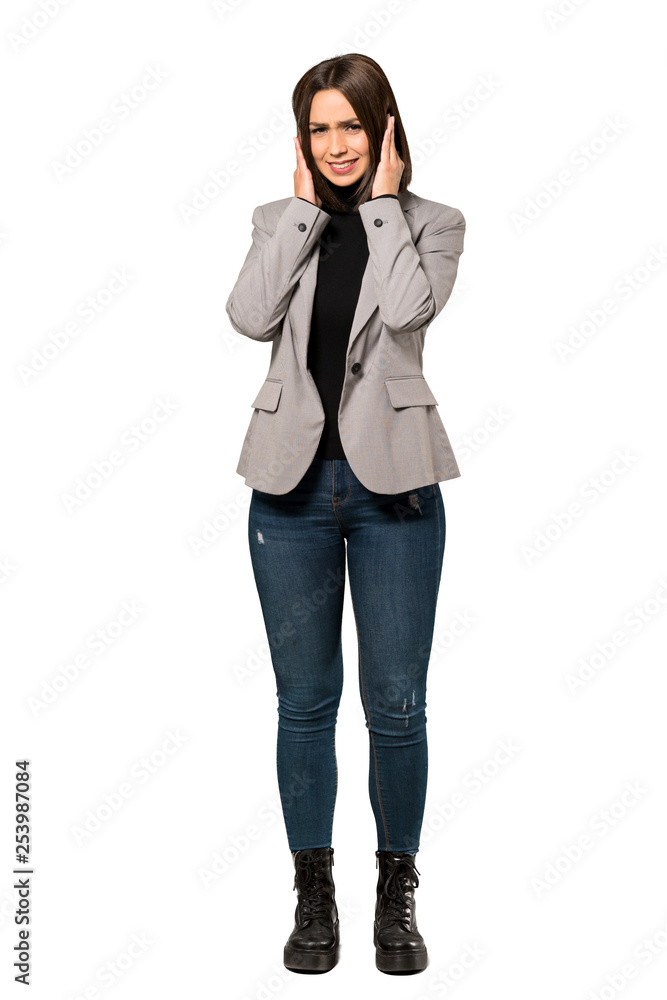 A full-length shot of a Young business woman frustrated and covering ears with hands over isolated white background