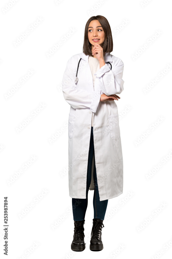 A full-length shot of a Young doctor woman thinking an idea while looking up over isolated white background A full-length shot of a Young doctor woman thinking an idea while looking up over isolated white background