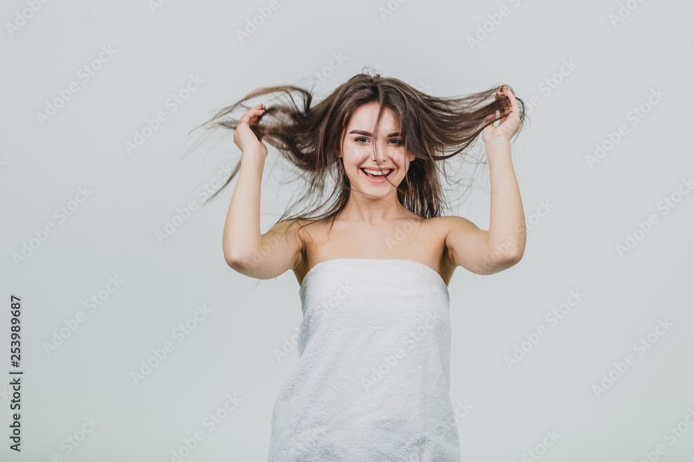 Naklejka premium Forgetting that I am an adult. Playful, happy and children's attractive female rough hair, smiling widely, holding hands with the assistant and pulling her hair down, playing with the sling, as if