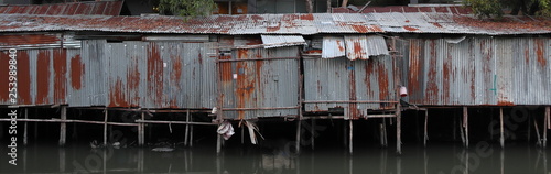 Zinc house a shabby old dilapidated corrugated iron building on the water. Bangkok, Thailand