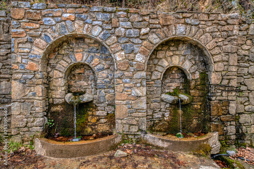 Water gushing. Stone wall water fountain. Close up of water gushing