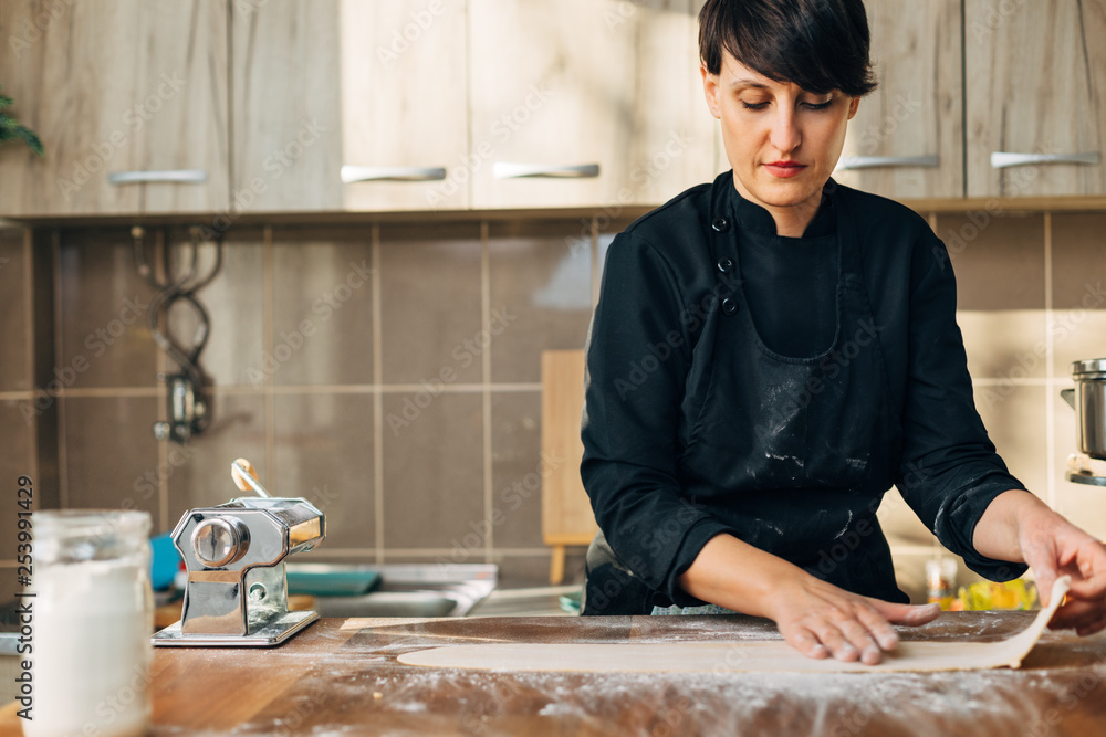 Female chef making pasta. Kneading rolling. Pasta maker Female chef making pasta. Kneading rolling. Pasta maker