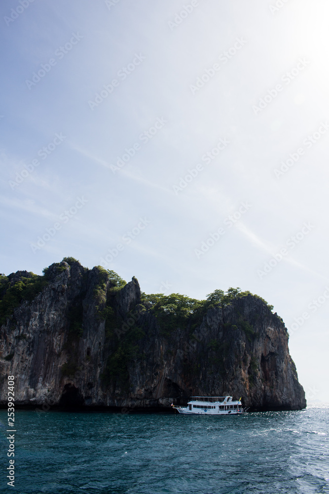 tourist boat visiting a cave in a cliff in thailand tourist boat visiting a cave in a cliff in thailand