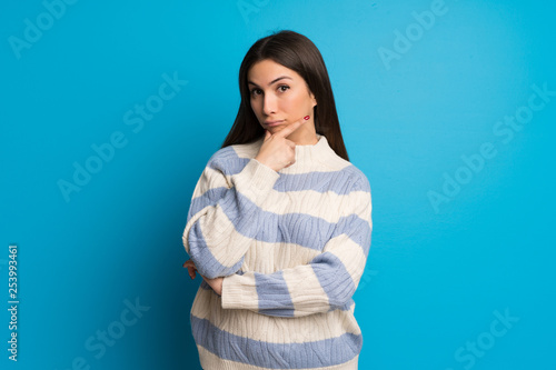 Young woman over blue wall looking to the front