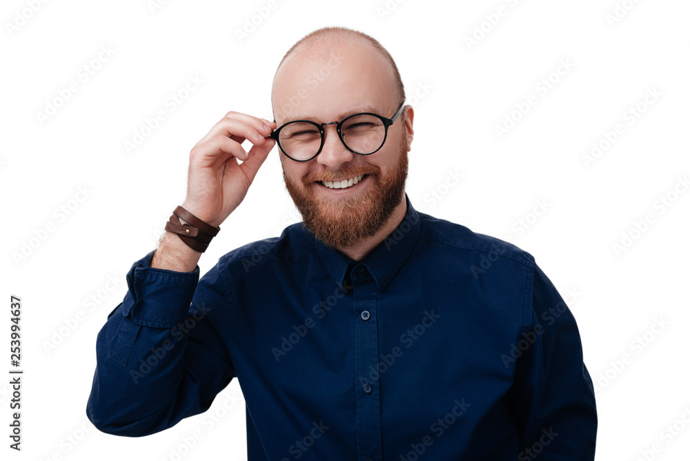 © Vulp - Young bearded man wearing dark blue shirt and glasses looking at camera on white background.