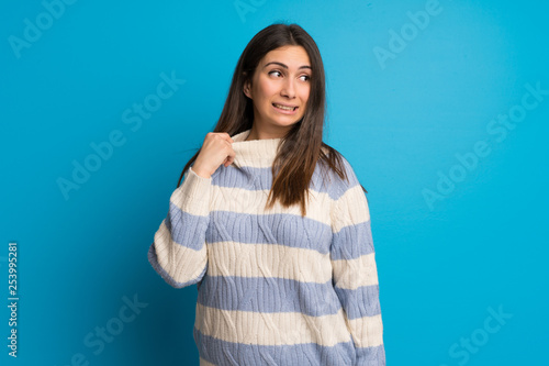Young woman over blue wall with tired and sick expression