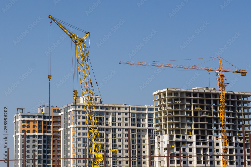 Construction crane and high-rise building under construction Construction crane and high-rise building under construction