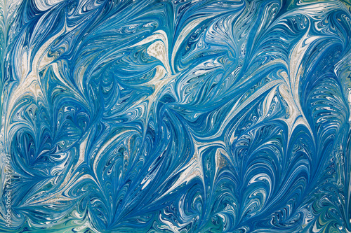 Beautiful abstract drawing technique Ebru in blue .Turkish style of painting Ebru on water with acrylic paints swirls waves.A stylish combination of natural luxury 