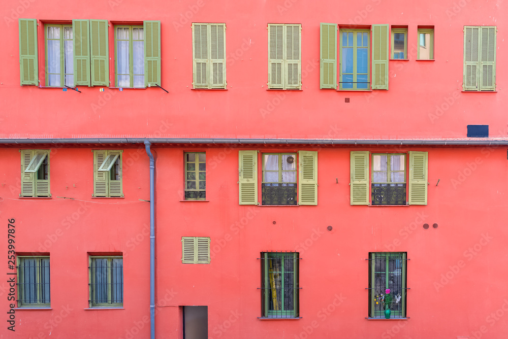 Nice, France, colorful red facade, with typical windows and shutters 