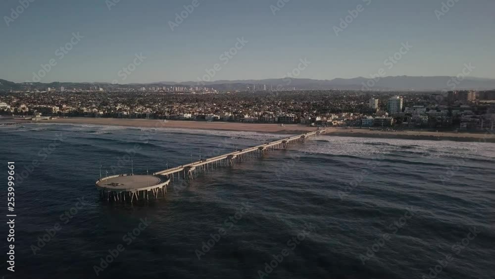 Aerial rotation drone view over Santa Monica pier, Venice beach coastline looking across city skyline. Aerial rotation drone view over Santa Monica pier, Venice beach coastline looking across city skyline.