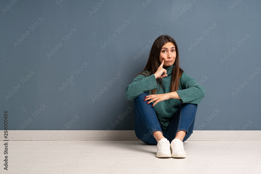 Young woman sitting on the floor Looking front Young woman sitting on the floor Looking front