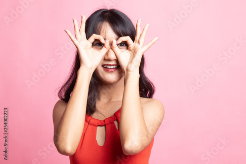 Asian woman do funny double OK sign as glasses.