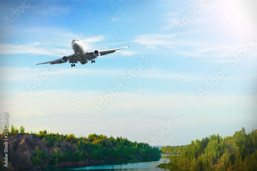 the journey, the plane flies in the blue sky against the backdrop of a mountain landscape and river, flies away