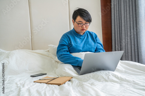 Young woman using laptop in hotel room