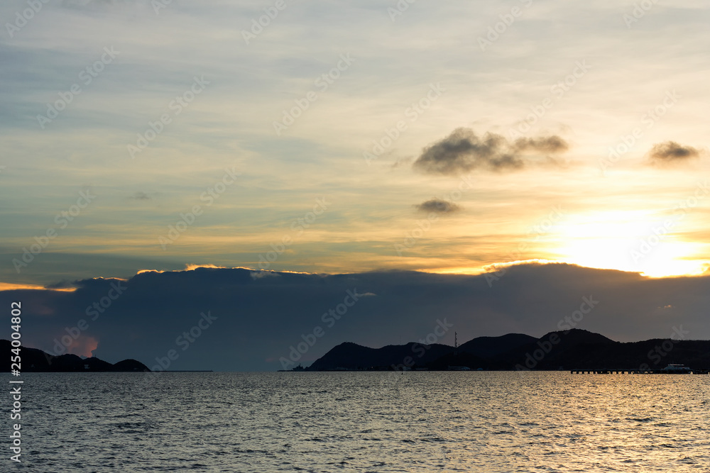 beautiful seascape, golden sunset behind island and above the sea at asia