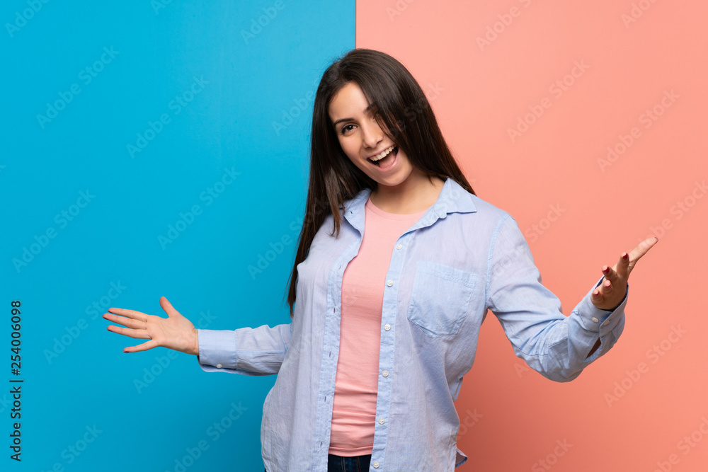Young woman over pink and blue wall proud and self-satisfied in love yourself concept Young woman over pink and blue wall proud and self-satisfied in love yourself concept