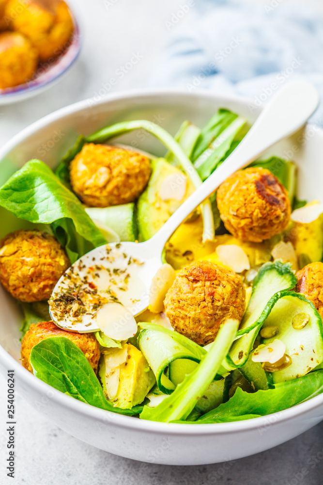 Vegan salad with beans meatballs, avocado and cucumber in white bowl. Vegan salad with beans meatballs, avocado and cucumber in white bowl.