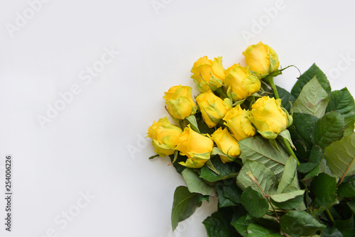 bouquet fresh yellow roses flowers with leaves white background. Flat lay, top view. corner frame composition. postcard birthday celebration father's day, mother's day, birthday floral arrangement