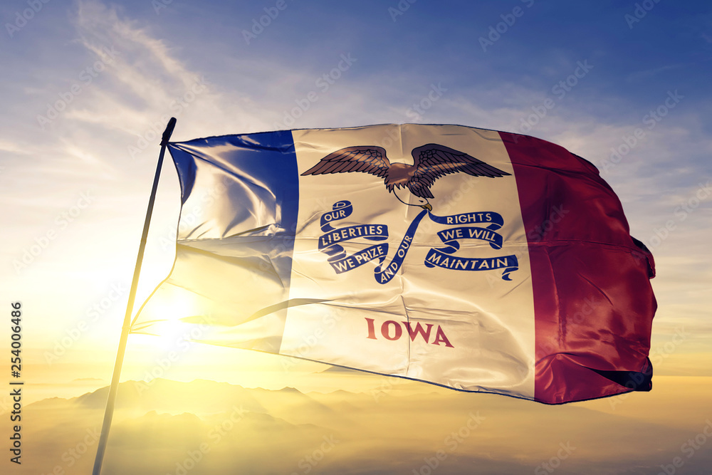 Iowa state of United States flag waving on the top sunrise mist fog