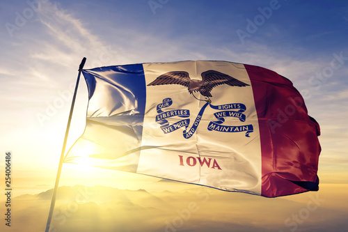 Iowa state of United States flag waving on the top sunrise mist fog photo