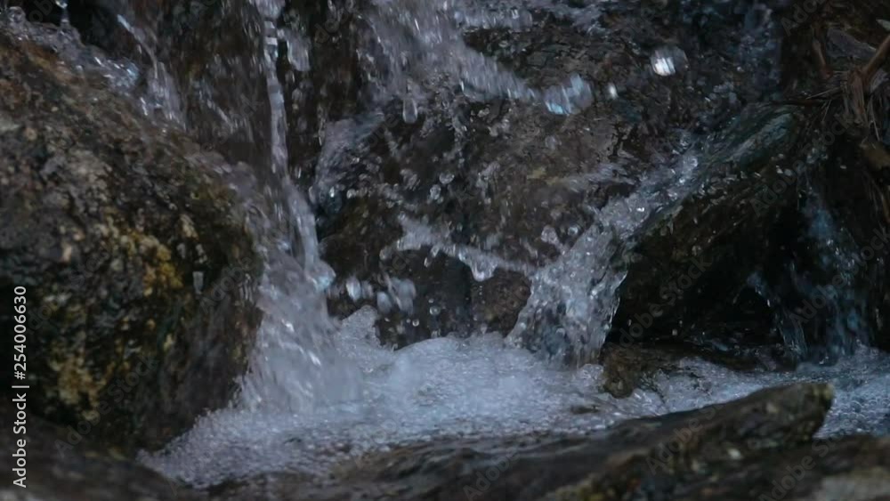 Super slow motion of small brook. Close up on water splashing down on rocks. Super slow motion of small brook. Close up on water splashing down on rocks.