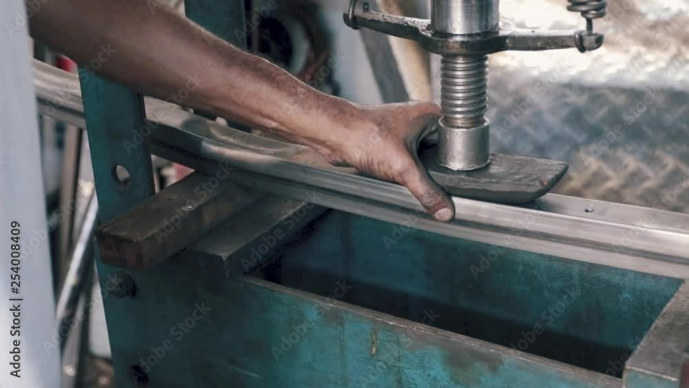 Slow motion of close up shot of a man bending metal piece on a machine, dirt place, hands and heavy work Slow motion of close up shot of a man bending metal piece on a machine, dirt place, hands and heavy work