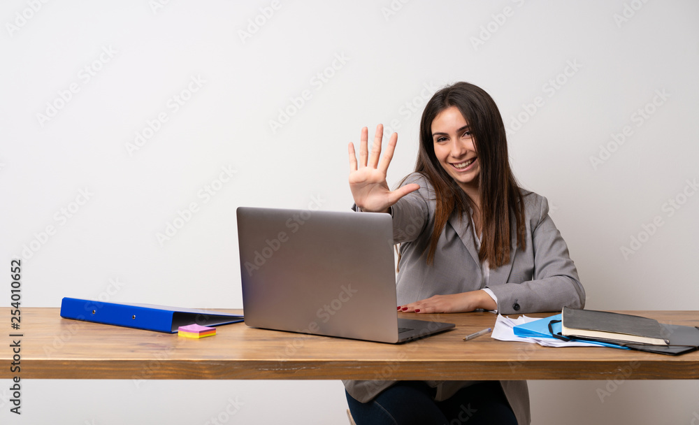 Business woman in a office counting five with fingers Business woman in a office counting five with fingers