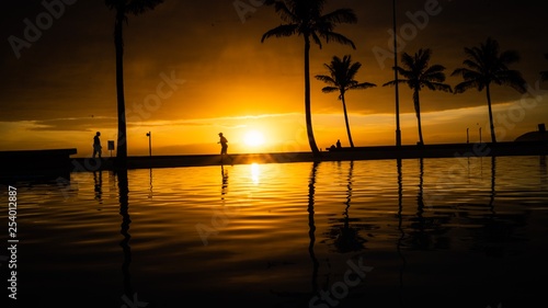 Sunrise with silhouette runner and reflection in pool