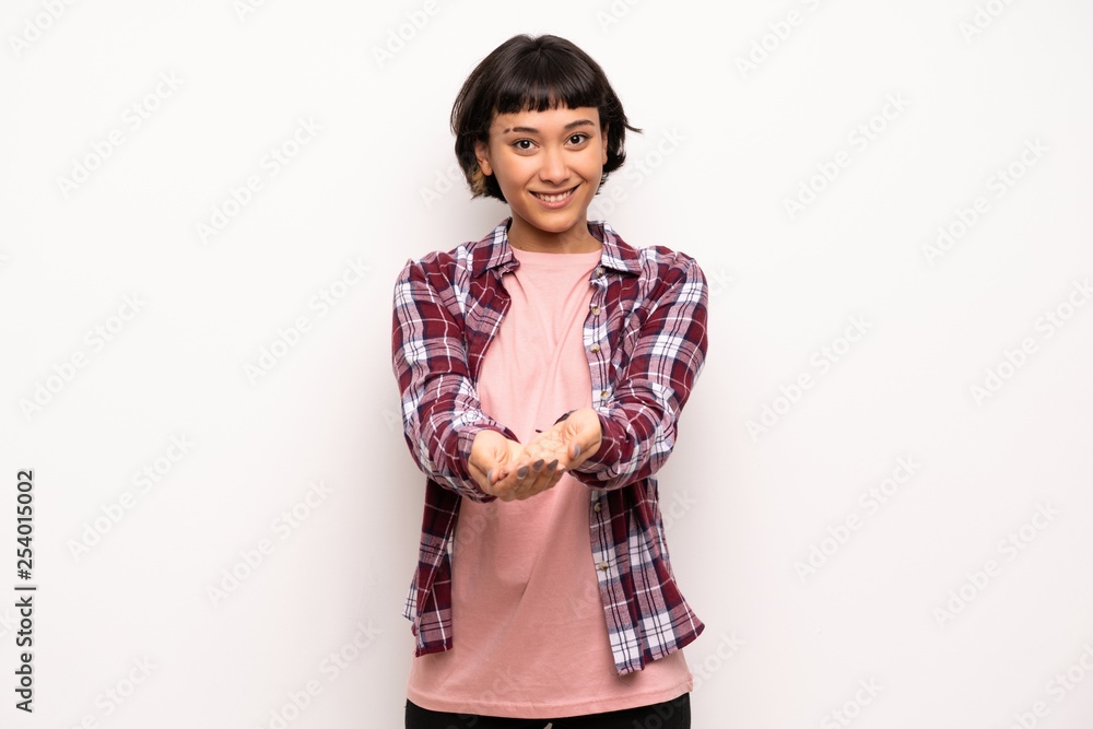 Young woman with short hair holding copyspace imaginary on the palm to insert an ad Young woman with short hair holding copyspace imaginary on the palm to insert an ad