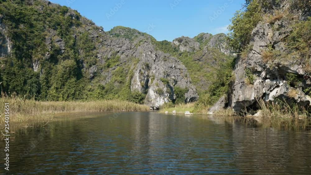Scenic view of beautiful karst scenery, wetlands seen from the boat at Van Long Nature Reserve, Vietnam. Tourists traveling in small boat in tranquil landscape. Scenic view of beautiful karst scenery, wetlands seen from the boat at Van Long Nature Reserve, Vietnam. Tourists traveling in small boat in tranquil landscape.