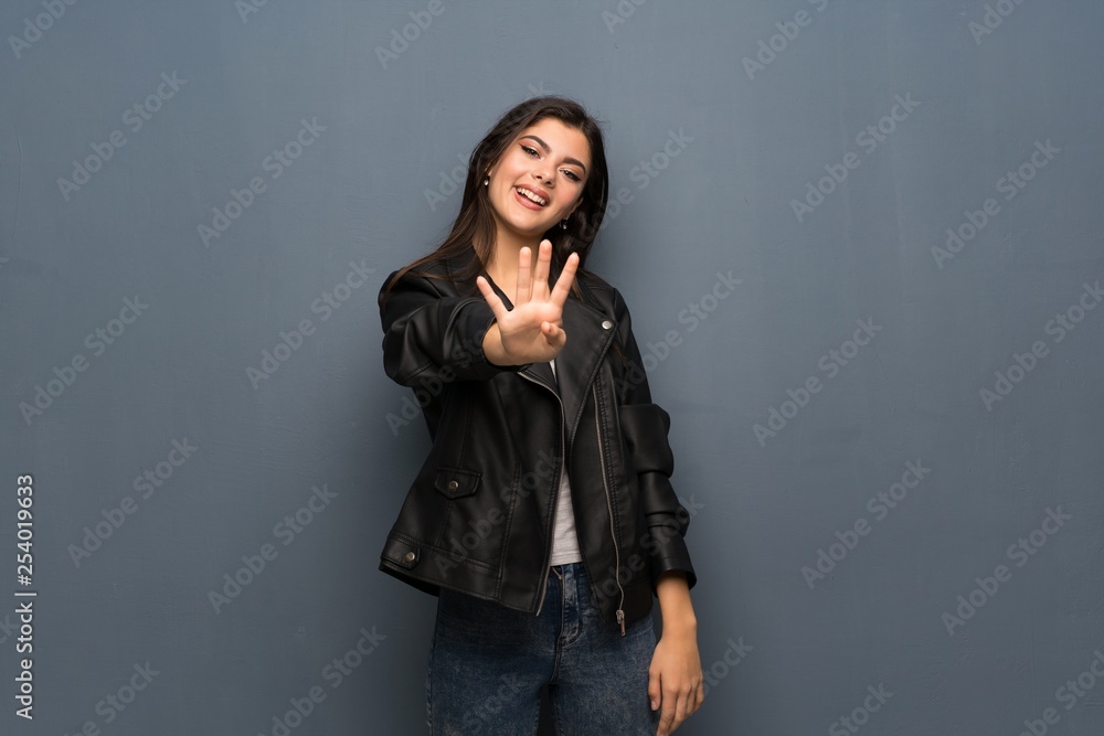 Teenager girl over grey wall happy and counting four with fingers Teenager girl over grey wall happy and counting four with fingers
