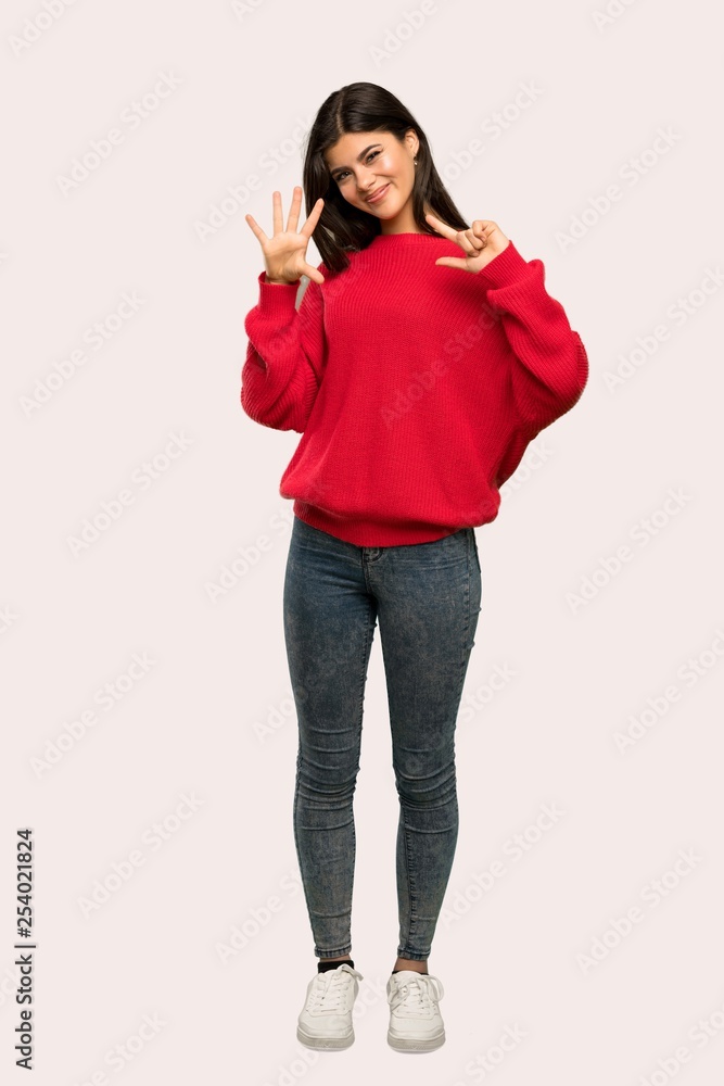 A full-length shot of a Teenager girl with red sweater counting seven with fingers over isolated background A full-length shot of a Teenager girl with red sweater counting seven with fingers over isolated background