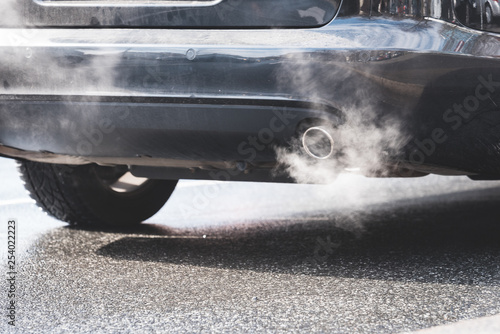 exhaust gas coming out of an exhaust pipe of a car on a street photo