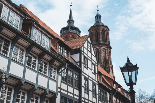 old Fachwerkhaus or half-timbered house with a church in the back and a lantern in the front in Goettingen, Germany