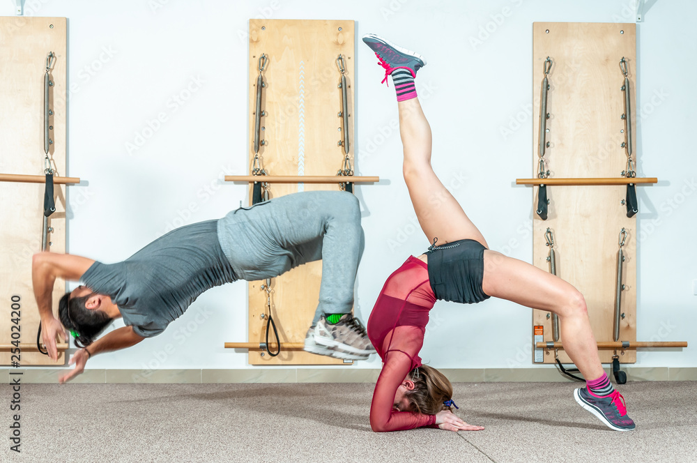 Young yoga fitness acrobatic couple having fun in the gym performing and  practicing funny acrobat selective focus with motion blur real people  training workout Stock Photo | Adobe Stock