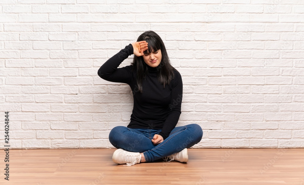 Woman sitting on the floor with tired and sick expression Woman sitting on the floor with tired and sick expression
