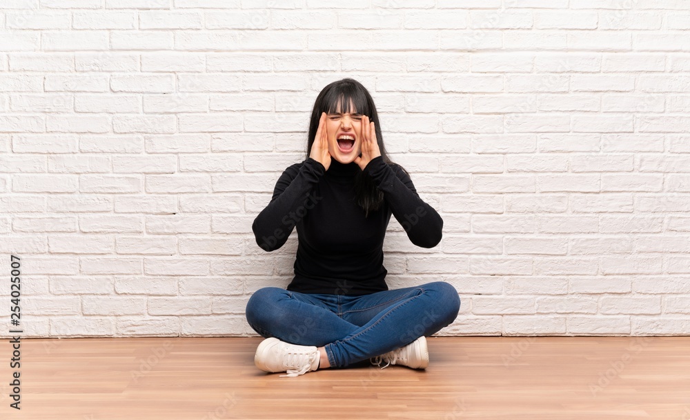 Woman sitting on the floor shouting and announcing something Woman sitting on the floor shouting and announcing something