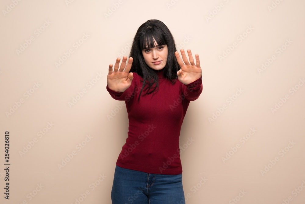 Young woman with red turtleneck making stop gesture for disappointed with an opinion Young woman with red turtleneck making stop gesture for disappointed with an opinion