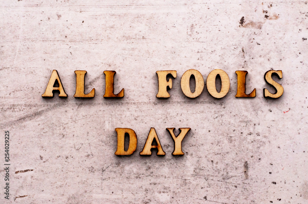 Inscription ALL FOOLS DAY in wooden letters on a light background Inscription ALL FOOLS DAY in wooden letters on a light background