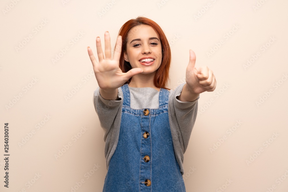 Young redhead woman over isolated background counting six with fingers Young redhead woman over isolated background counting six with fingers