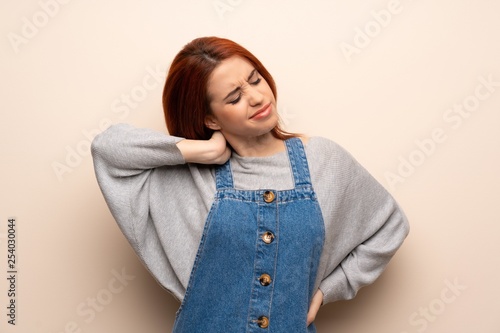 Young redhead woman over isolated background with neckache