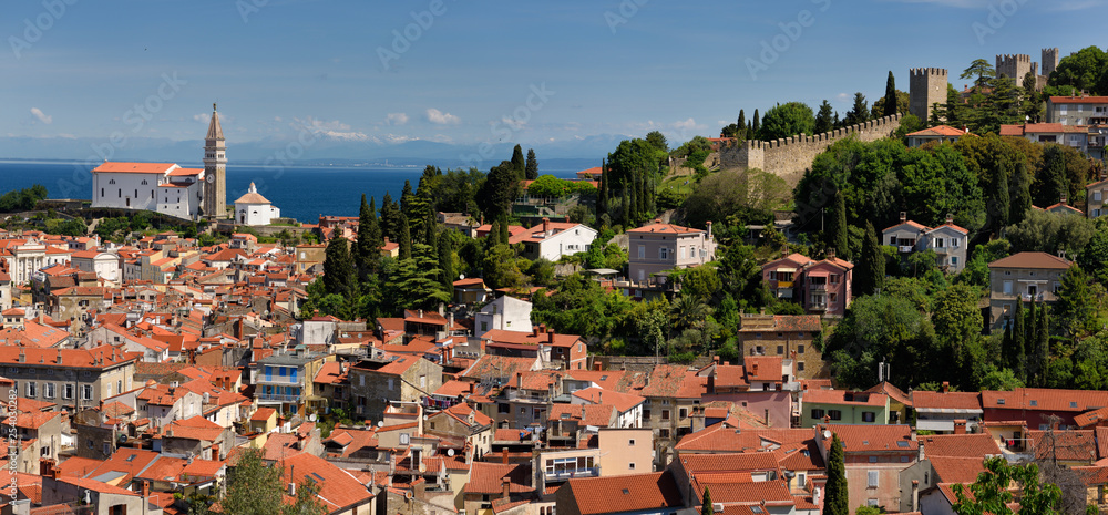 Panorama of Piran Slovenia on Gulf of Trieste Adriatic sea with St George's Catholic Cathedral to the crenellated town walls with Kanin Mountains