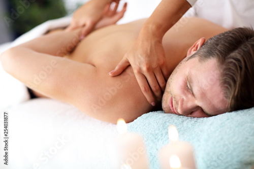 Handsome man having massage in spa salon